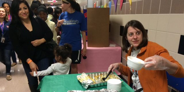 A teacher dishes up food at the Ousley Multi-cultural Festival