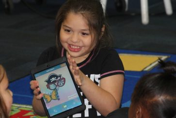 Student uses iPad in Wood Elementary library