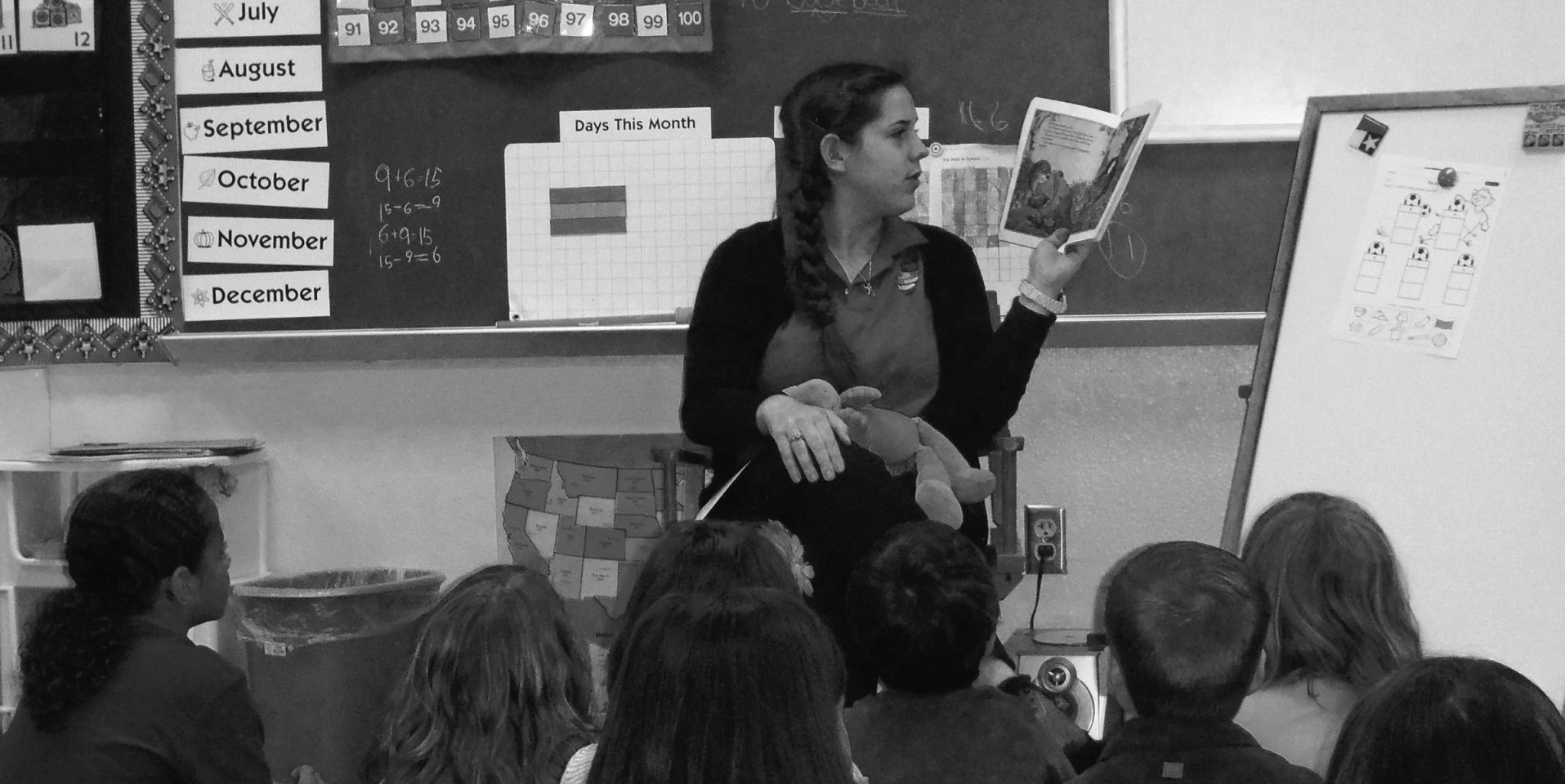 Student reading to younger students