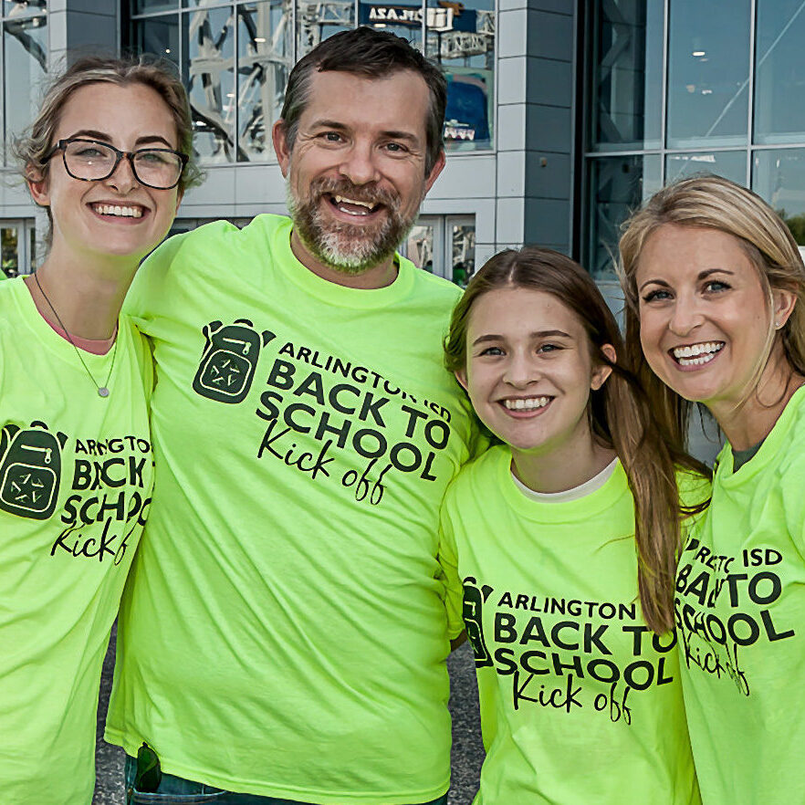 A family volunteering at the Back to School Kickoff event.