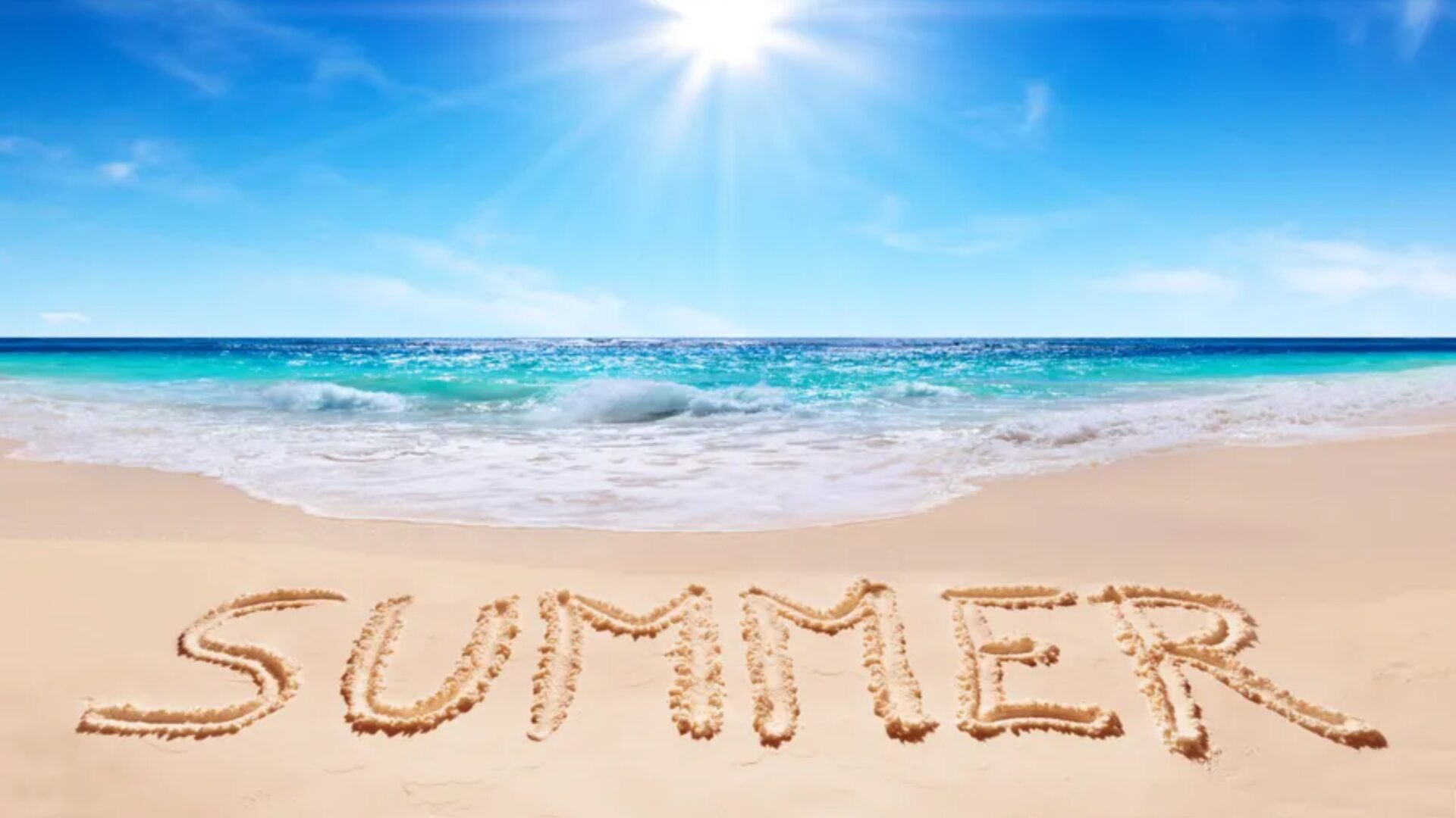 Summer written in the sand at beach